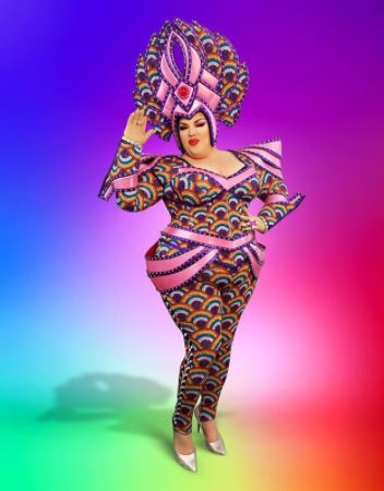 Drag Queen dressed in colorful clothing with a colorful head dress to match rainbow color background